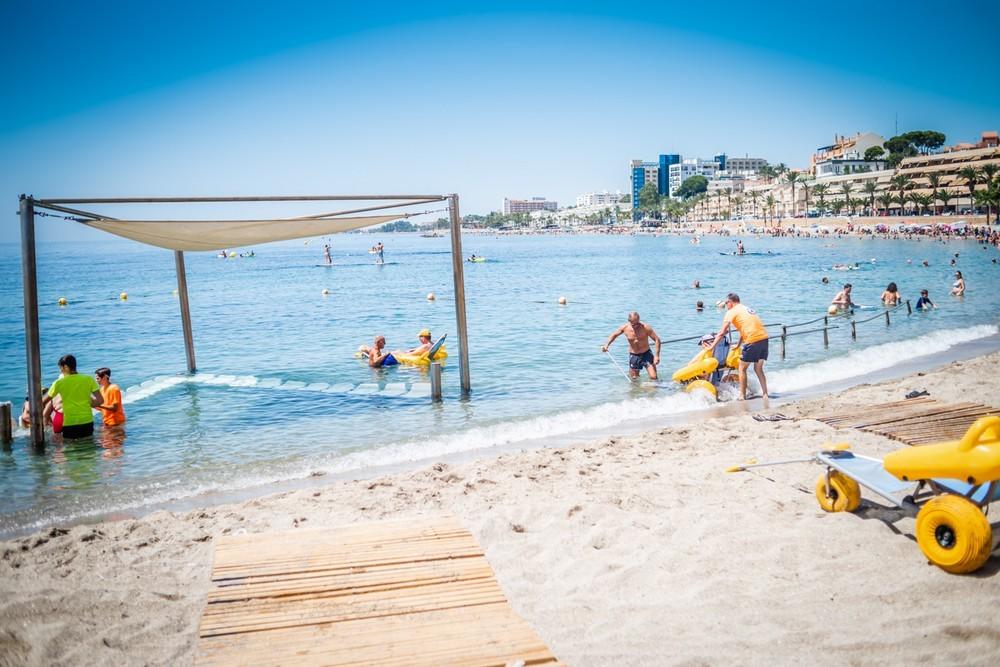 Ocho voluntarios atienden a bañistas con movilidad reducida en la playa adaptada de Aguadulce, referente en accesibilidad